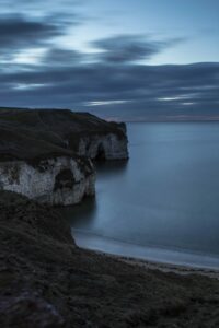 The white cliffs at Flamborough Head surrounded by blue waters.